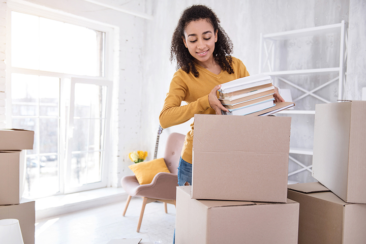 girl packing and unpacking moving boxes